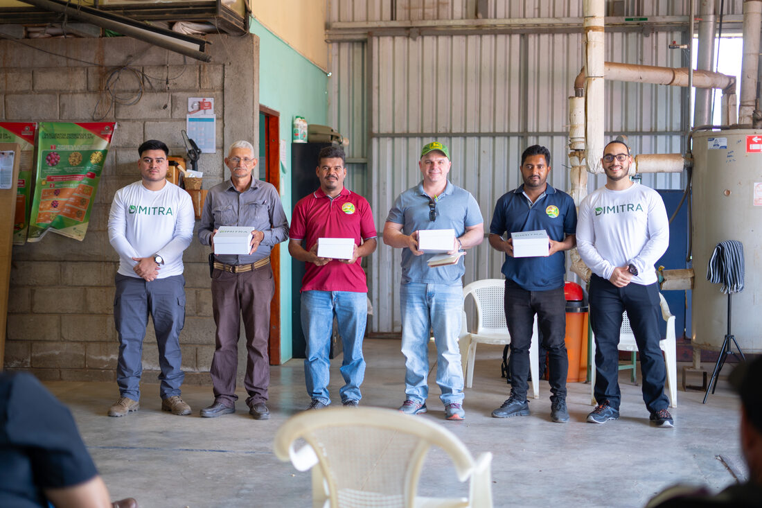 Dimitra team handing devices to a coffee cooperative